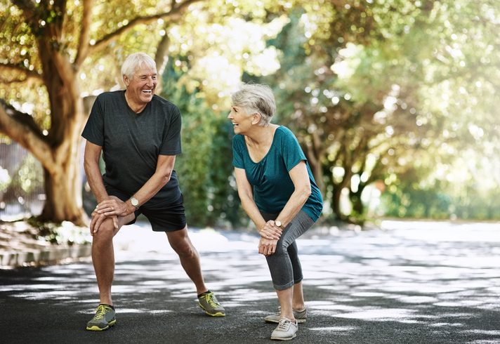Active Elderly Couple Exercising Outdoors In Athletic Attire